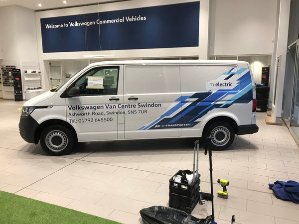 Volkswagen van in a showroom with 'Welcome to Volkswagen Commercial Vehicles' sign.